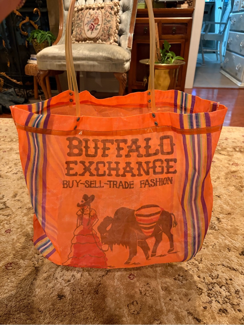 Buffalo Exchange orange mesh bag with plastic tubing handles reusable shopping